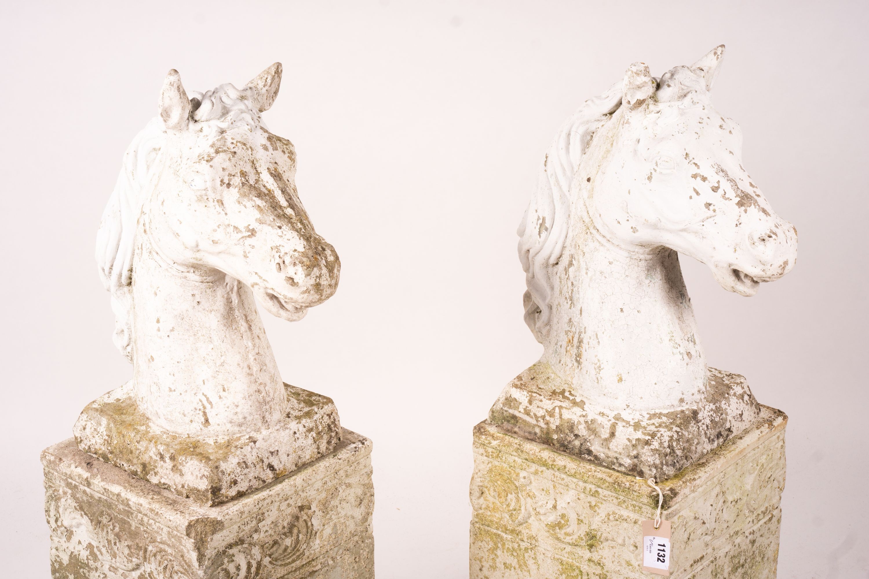 A pair of reconstituted stone horse's heads on plinth bases in the style of Austin and Seeley, height 104cm